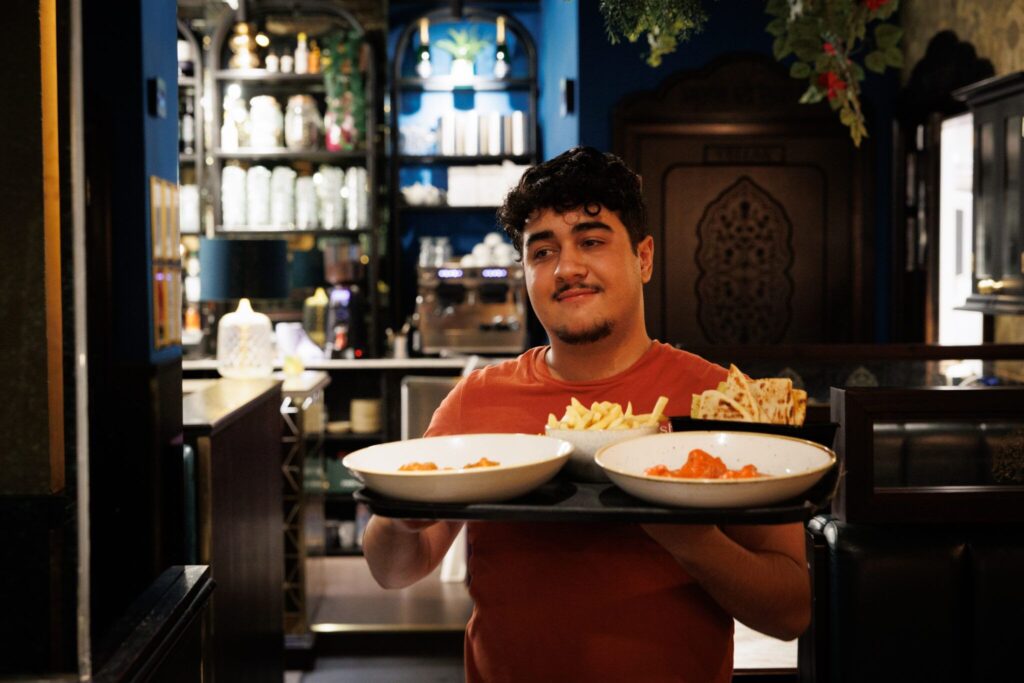 Namaste server carrying lunch dishes in Glasgow city centre